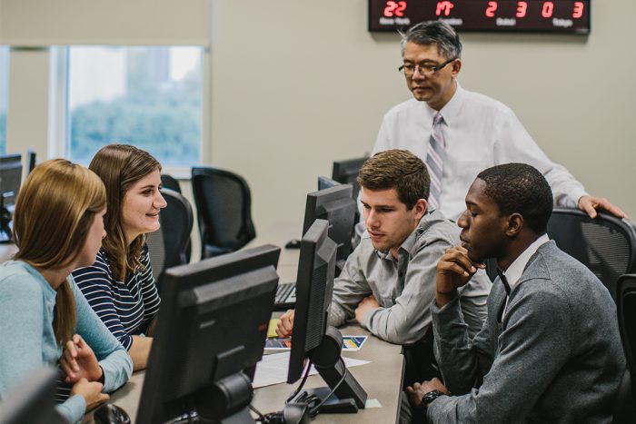 Students and professor working together in class