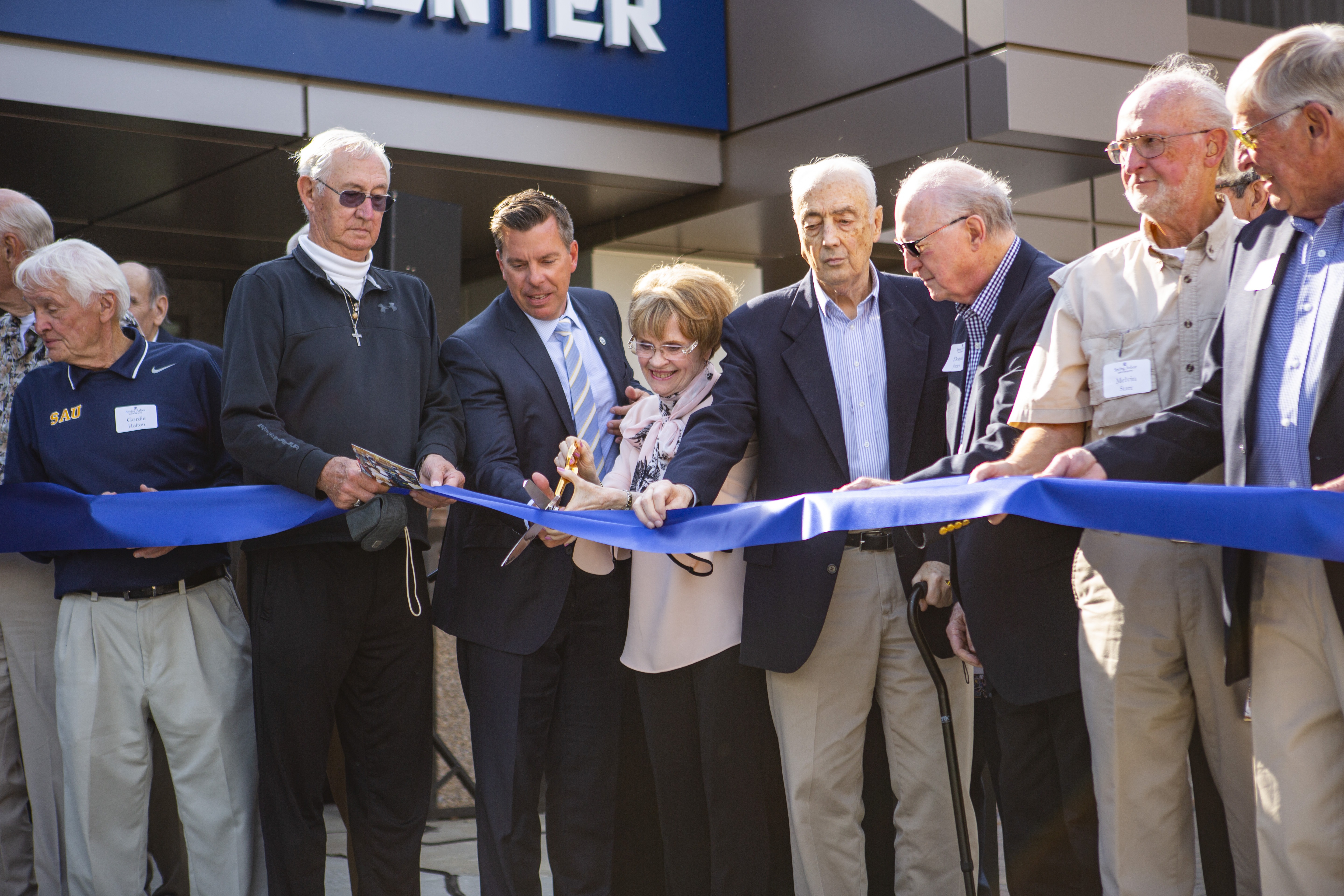 SAU President Dr. Brent Ellis and other members of the community cut the ribbon during the McDonald Athletic Center Dedication