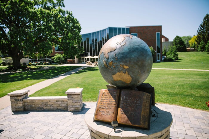 Statue of Globe and book on campus.